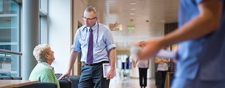 A doctor giving patient support to an elderly women in the hospital